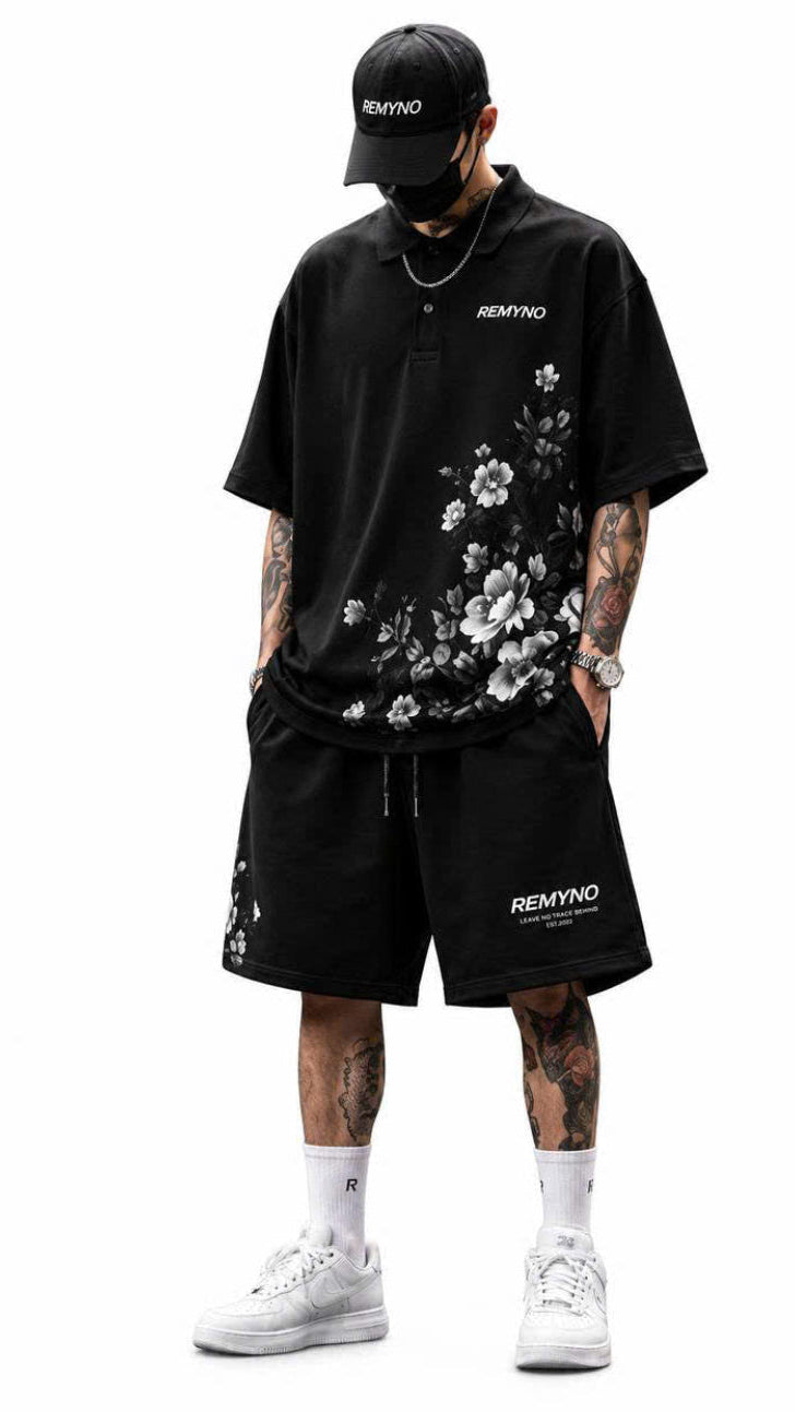 Person wearing a black floral shirt and shorts with 'RemyNo' branding on a white background